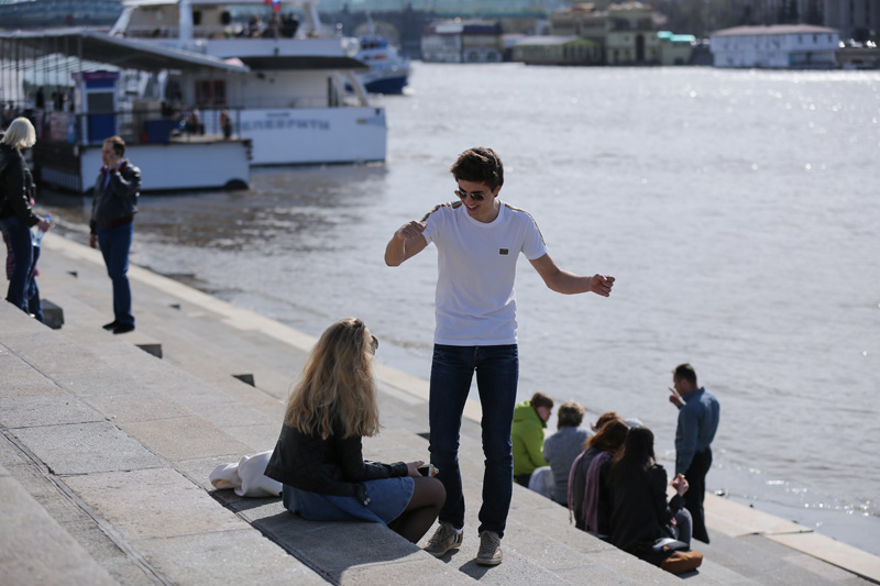 图为一对青年在莫斯科河畔交谈