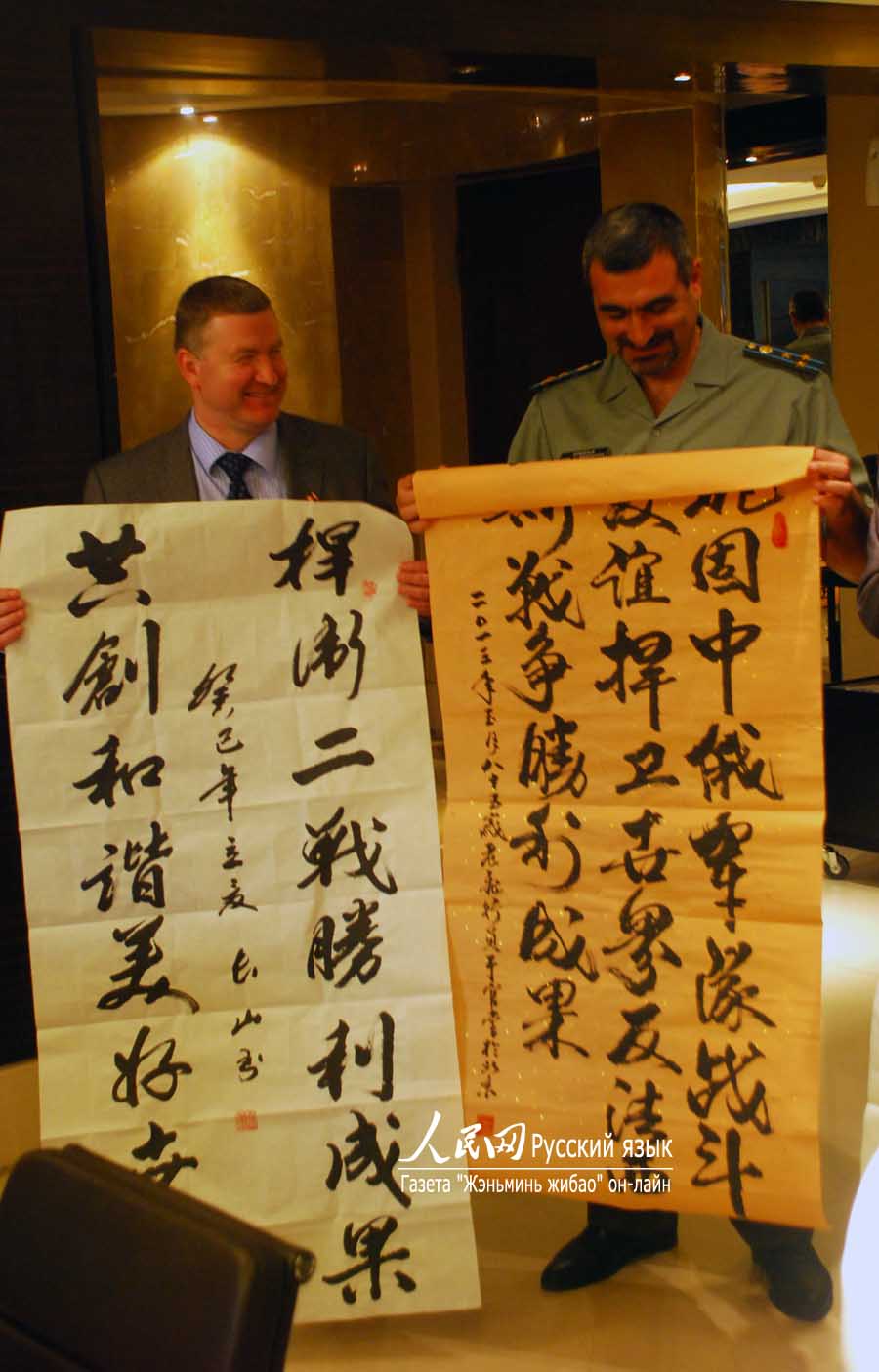 乌克兰（左）与亚美尼亚（右）武官接受中国老兵赠送的字画 孙乃绪 摄