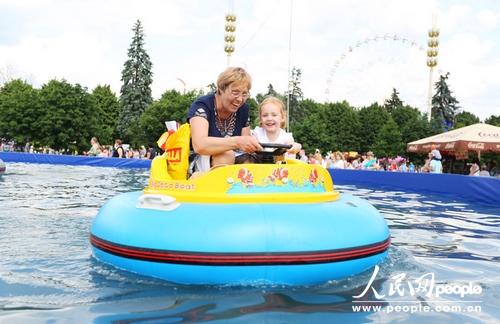 一名家长在陪孩子体验水上皮艇。（人民网记者 刘旭摄）