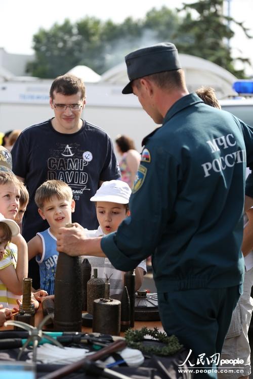 一名俄罗斯紧急情况部工作人员在现场为孩子们讲解安全常识。（人民网记者 刘旭摄）
