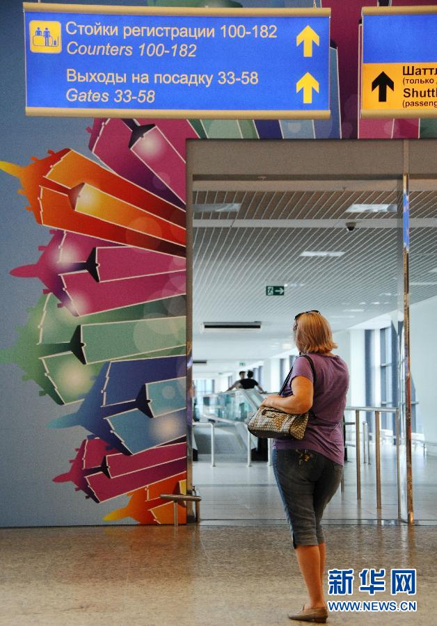 7月4日，在斯诺登目前滞留的俄罗斯莫斯科谢列梅捷沃机场，一名女士在连接D、E两座航站楼的通道入口处驻足。