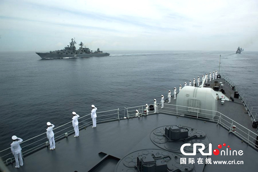 联演结束后，双方指挥员在瓦良格号巡洋舰上检阅两国海军舰艇编队   摄影：张群
