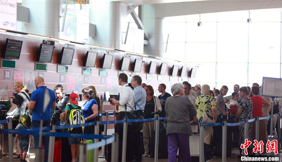 7月11日，莫斯科谢列梅捷沃机场国际航班起落照常，图为莫斯科谢列梅捷沃机场国际航班值机柜台前，乘客熙攘。中新社发 贾靖峰 摄
