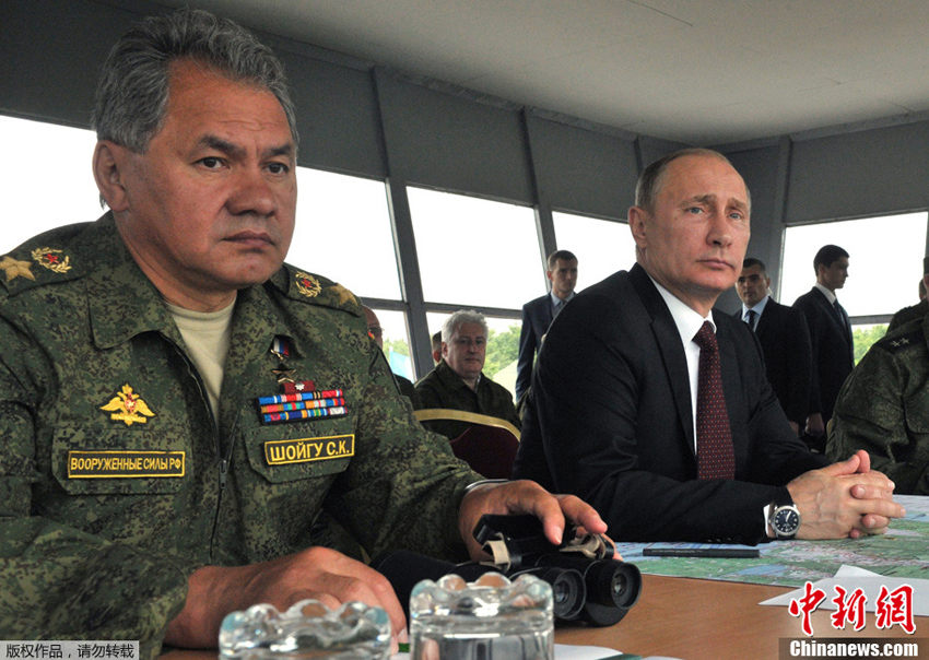 2013年7月16日，俄罗斯总统普京在远东萨哈林州视察了正在进行军事演习的部队。国防部长绍伊古（左）当天也陪同普京观摩了军演。萨哈林州濒临鄂霍次克海和日本隔海相望。图片来源：中新网