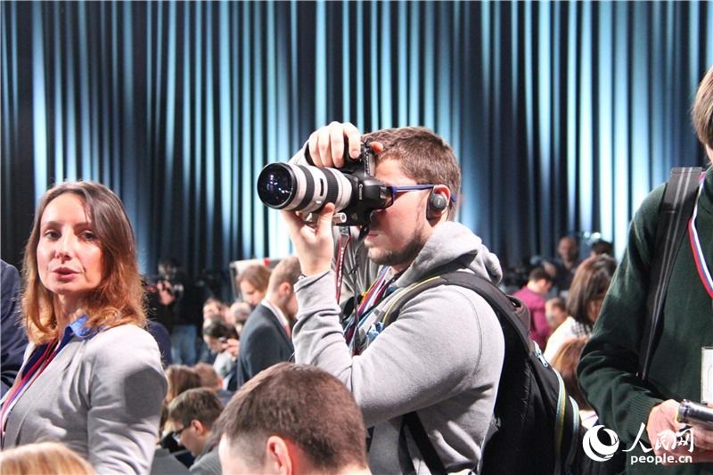 1. 俄罗斯总统普京2014年度大型记者招待会现场 图为会场上工作的记者 （人民网记者 华迪 摄）
